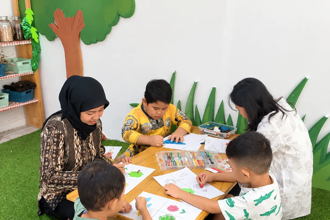 Children creating artwork together with their teachers